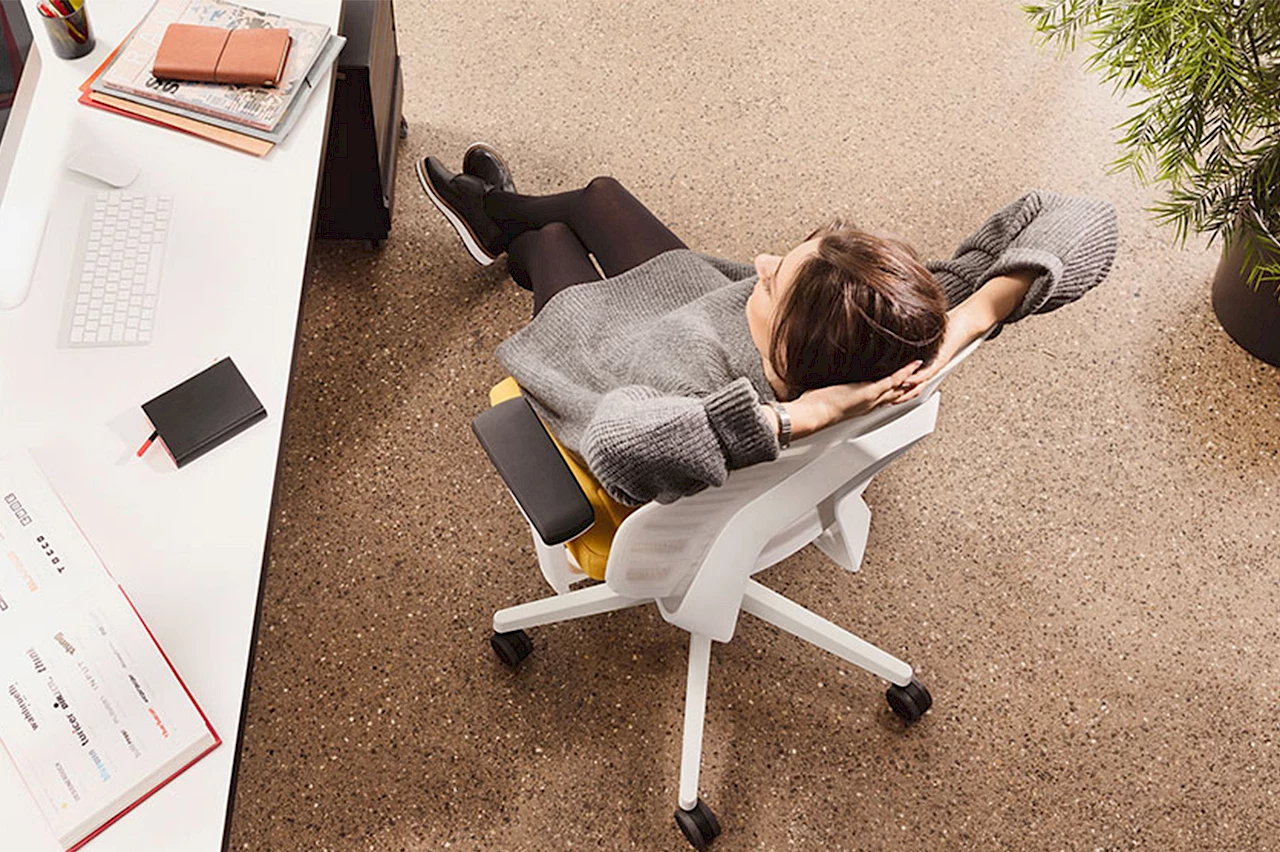 Frau sitzt entspannt an ihrem Arbeitsplatz. Bild: Interstuhl