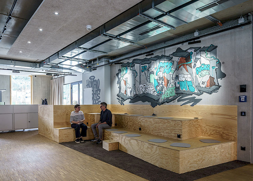 Tribüne im EG mit Graffiti. Bild: hehnpohl architektur bda Tribüne im EG mit Graffiti. Bild: hehnpohl architektur bda