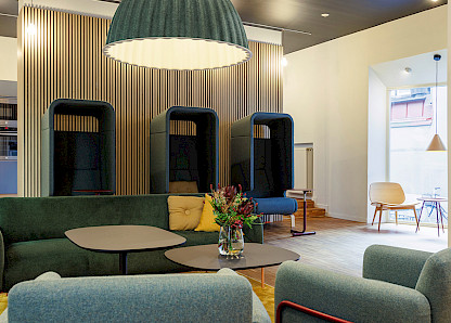 In der Lounge im Erdgeschoss schaffen das Sofa und der Sessel „Bolero“ mit dem Tisch „Matsumoto“ eine einladende Atmosphäre. Im Hintergrund befindet sich die „Point“-Sitzkabine, die einen geschützten Platz für Telefonate bietet. In der Lounge im Erdgeschoss schaffen das Sofa und der Sessel „Bolero“ mit dem Tisch „Matsumoto“ eine einladende Atmosphäre. Im Hintergrund befindet sich die „Point“-Sitzkabine, die einen geschützten Platz für Telefonate bietet.